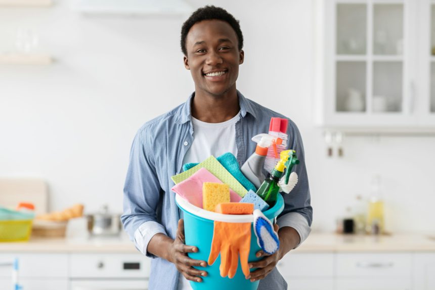 Cheerful african american man house-keeping on weekend