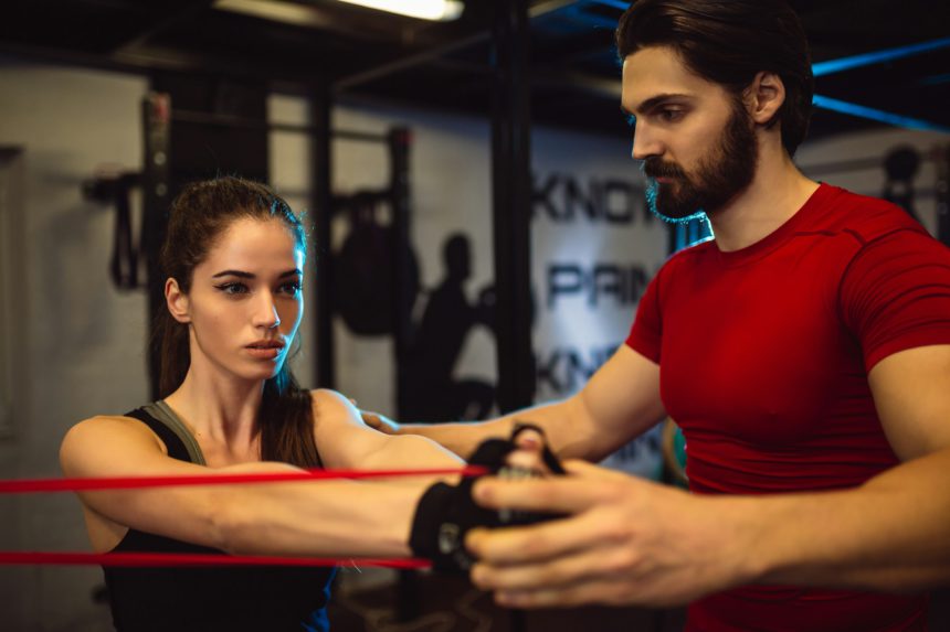 Personal trainer is motivated to show to his trainee how to get maximum from exercise